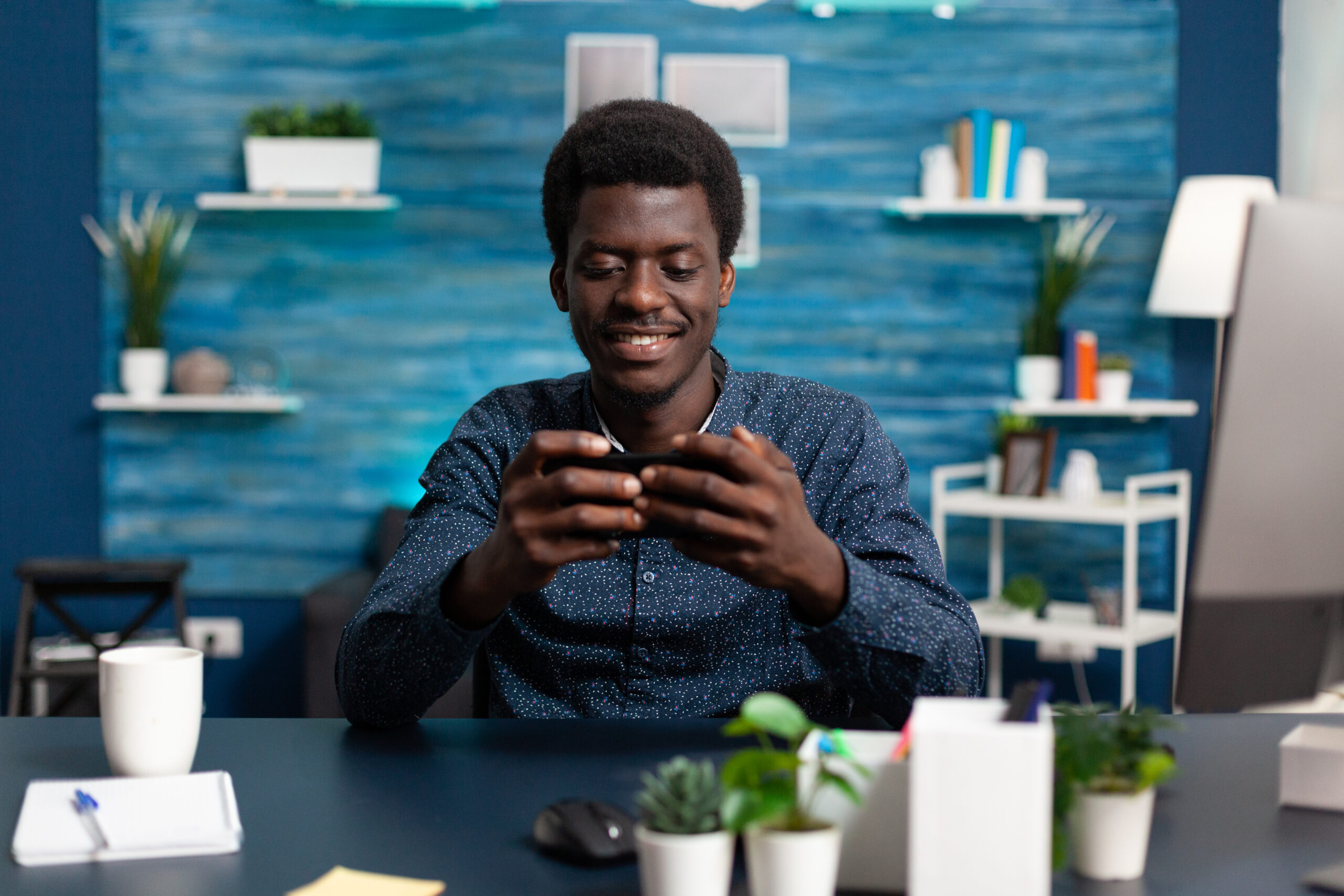 african american man smiling while using a smartphone