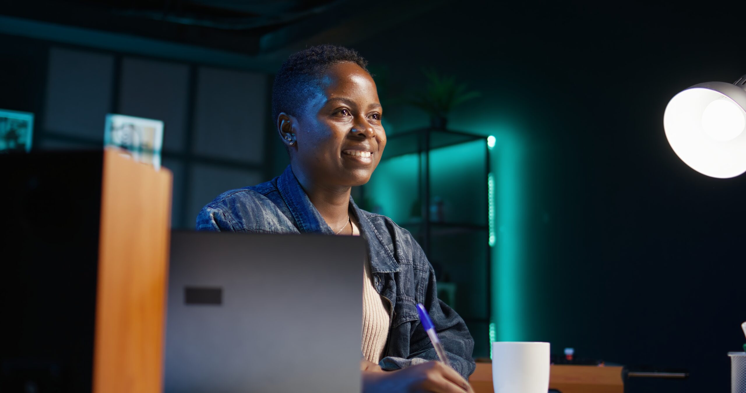 portrait of smiling woman sitting on chair at home office desk, writing notes